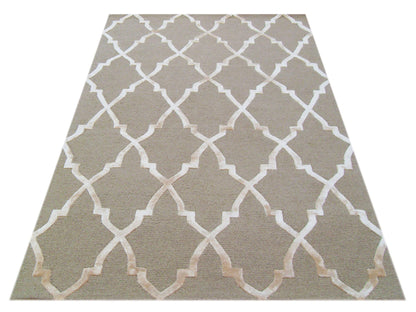 The KOHINOOR MOCCA is a rectangular hand-tufted rug featuring a light beige geometric lattice pattern on a taupe background, shown from above.